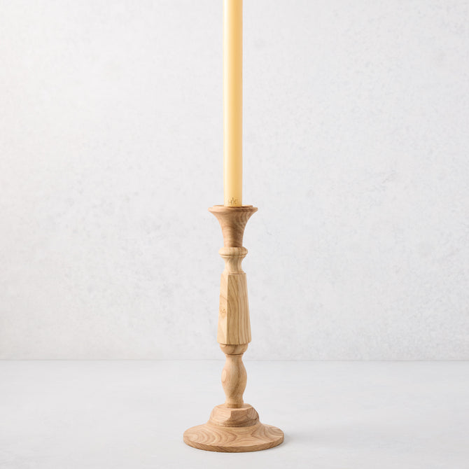 Small natural beechwood Georgian candlestick, 11"H, with a cream taper candle.