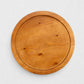 Small round natural reclaimed pine wood serving tray with raised rim and visible grain.