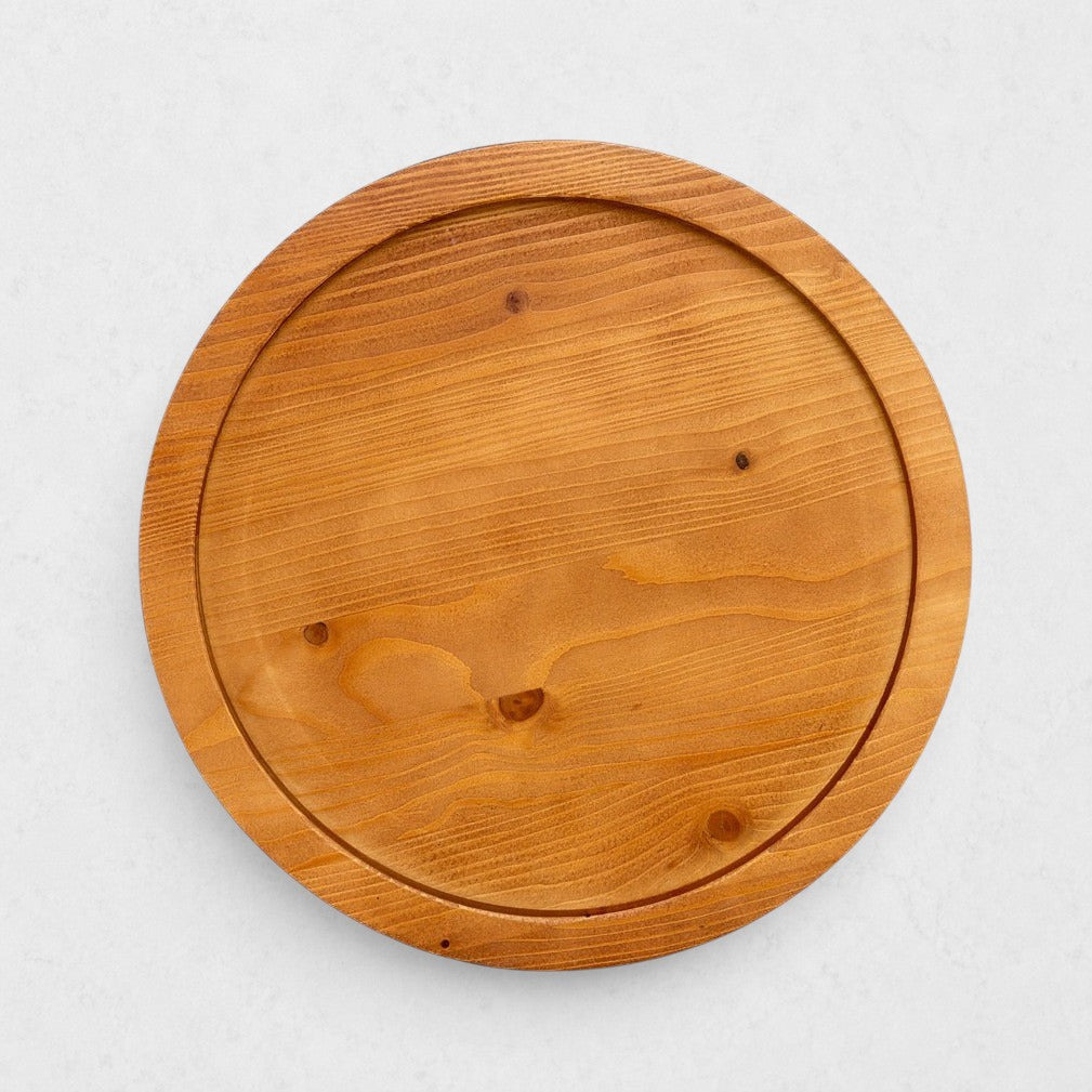 Small round natural reclaimed pine wood serving tray with raised rim and visible grain.