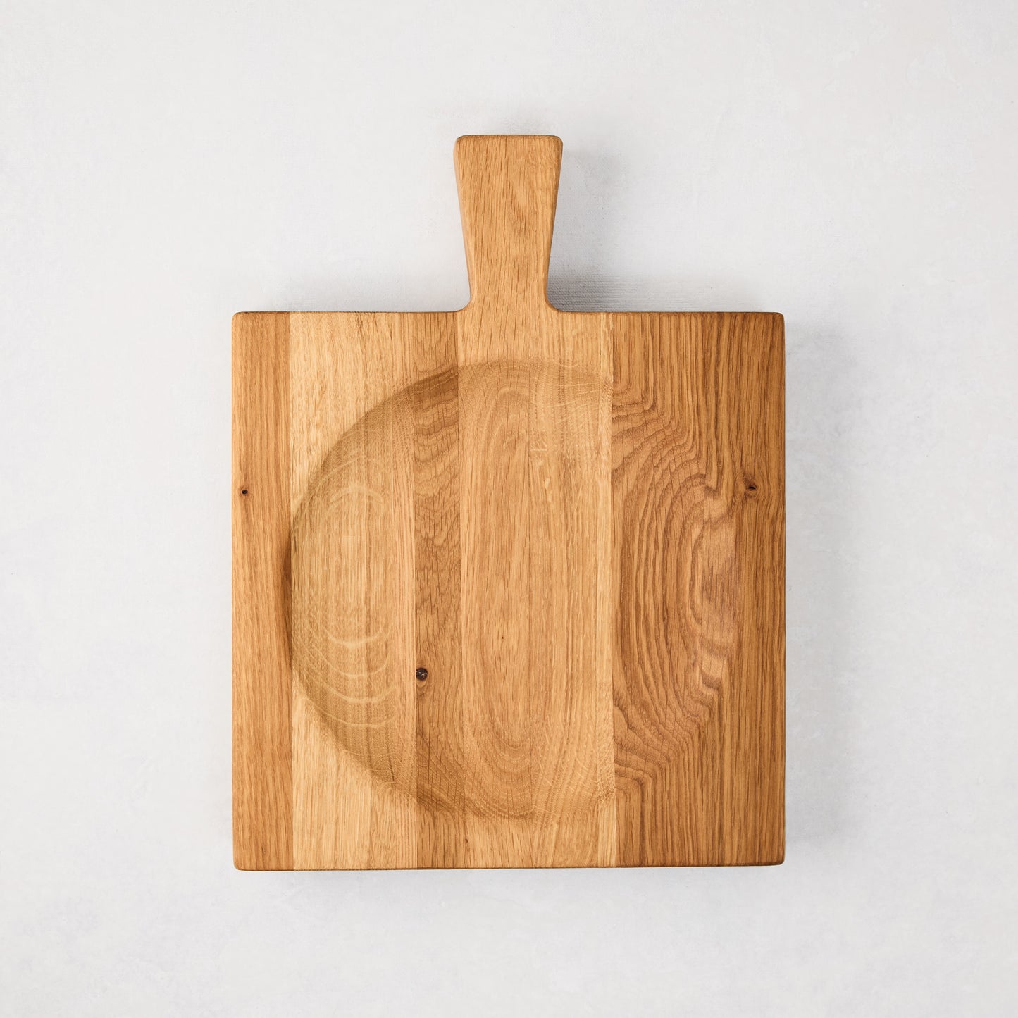 Small reclaimed oak wood cutting board bowl with handle and curved mezzaluna section.