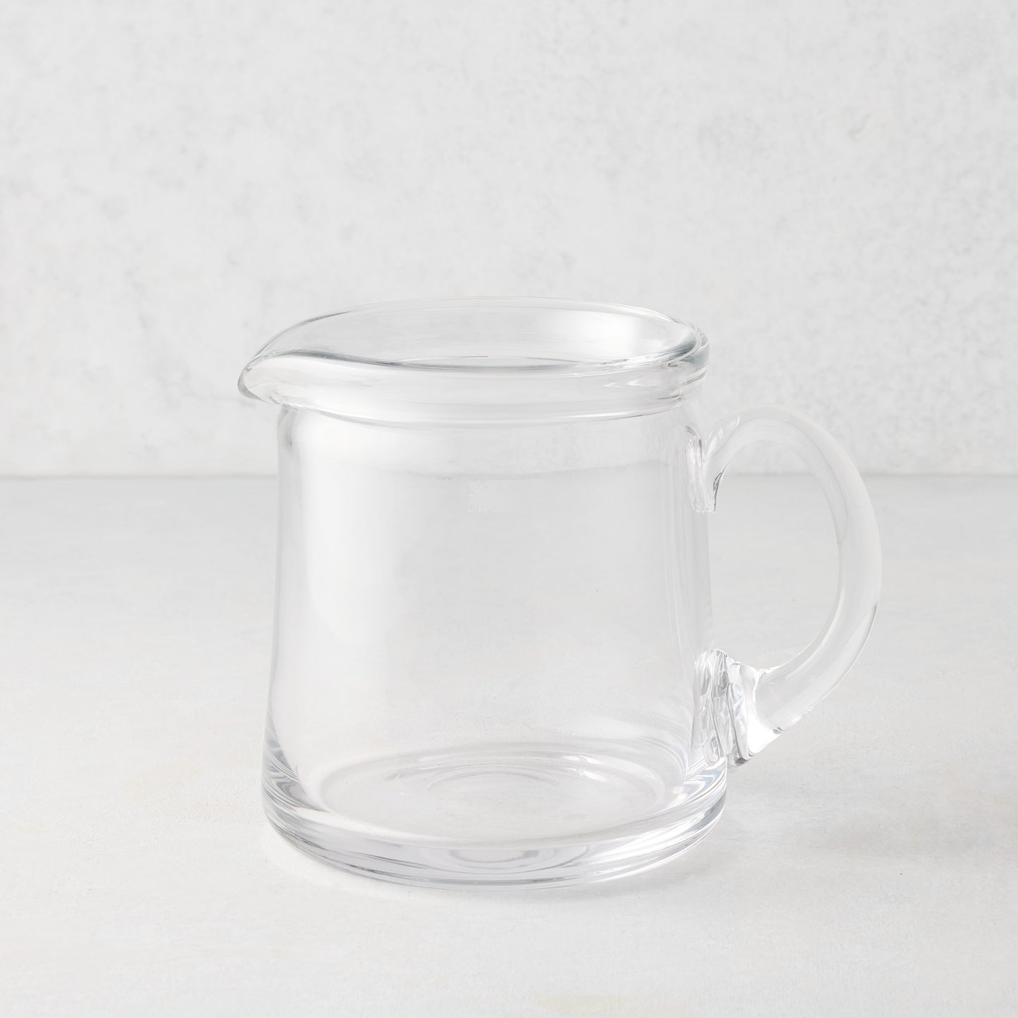 Small Oxford clear glass pitcher with a hand-molded rim and handle.