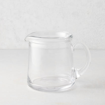 Small Oxford clear glass pitcher with a hand-molded rim and handle.