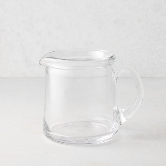 Small Oxford clear glass pitcher with a hand-molded rim and handle.