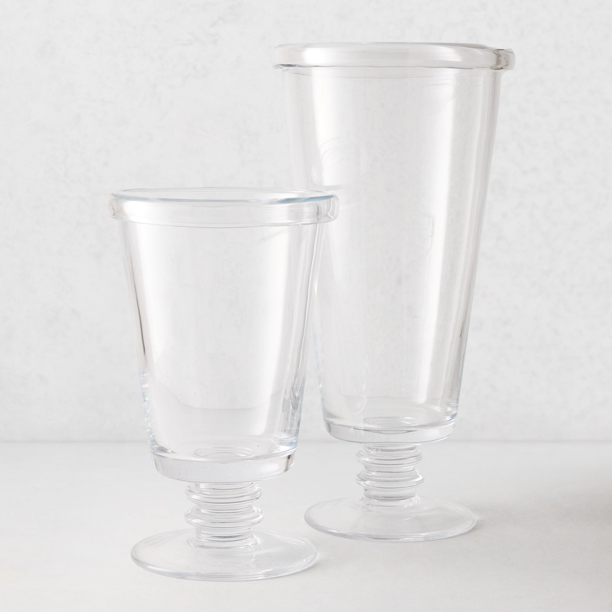 Two clear Oxford Glass Vases, one small and one large, with hand-molded folded rims and ribbed bases.