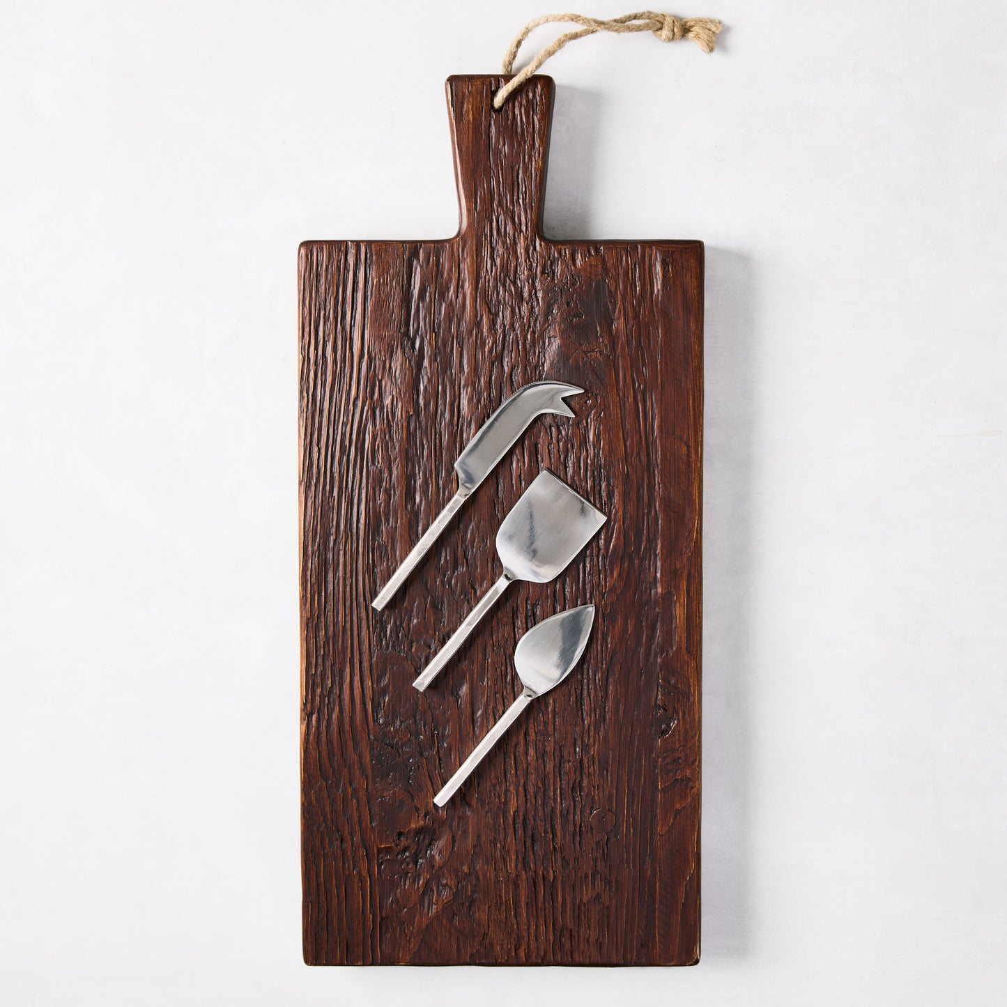 Dark European Pine wood plank serving board with three silver forged cheese knives.