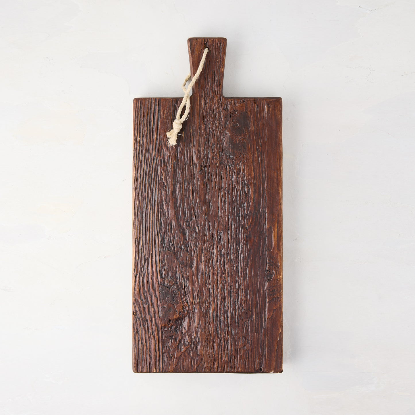 Dark brown European pine serving plank with handle and rope hanger.