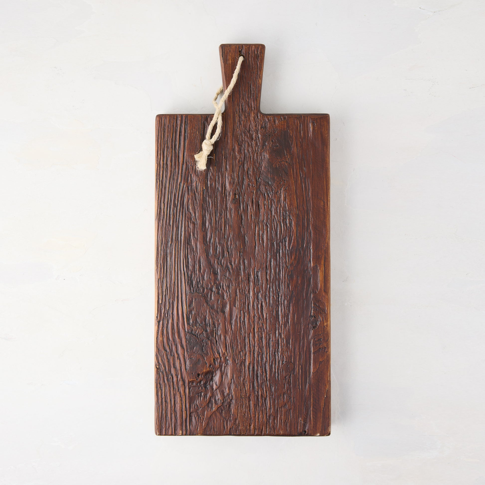 Dark brown European pine serving plank with handle and rope hanger.