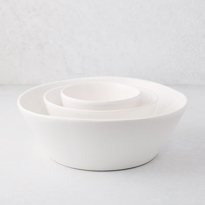 Set of three white spiral ceramic serving bowls, handmade in Portugal, nested on a light surface.