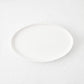 Small white oval stoneware serving platter with a minimalist design, 11.81 inches long.