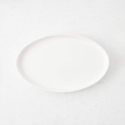 Small white oval stoneware serving platter with a minimalist design, 11.81 inches long.