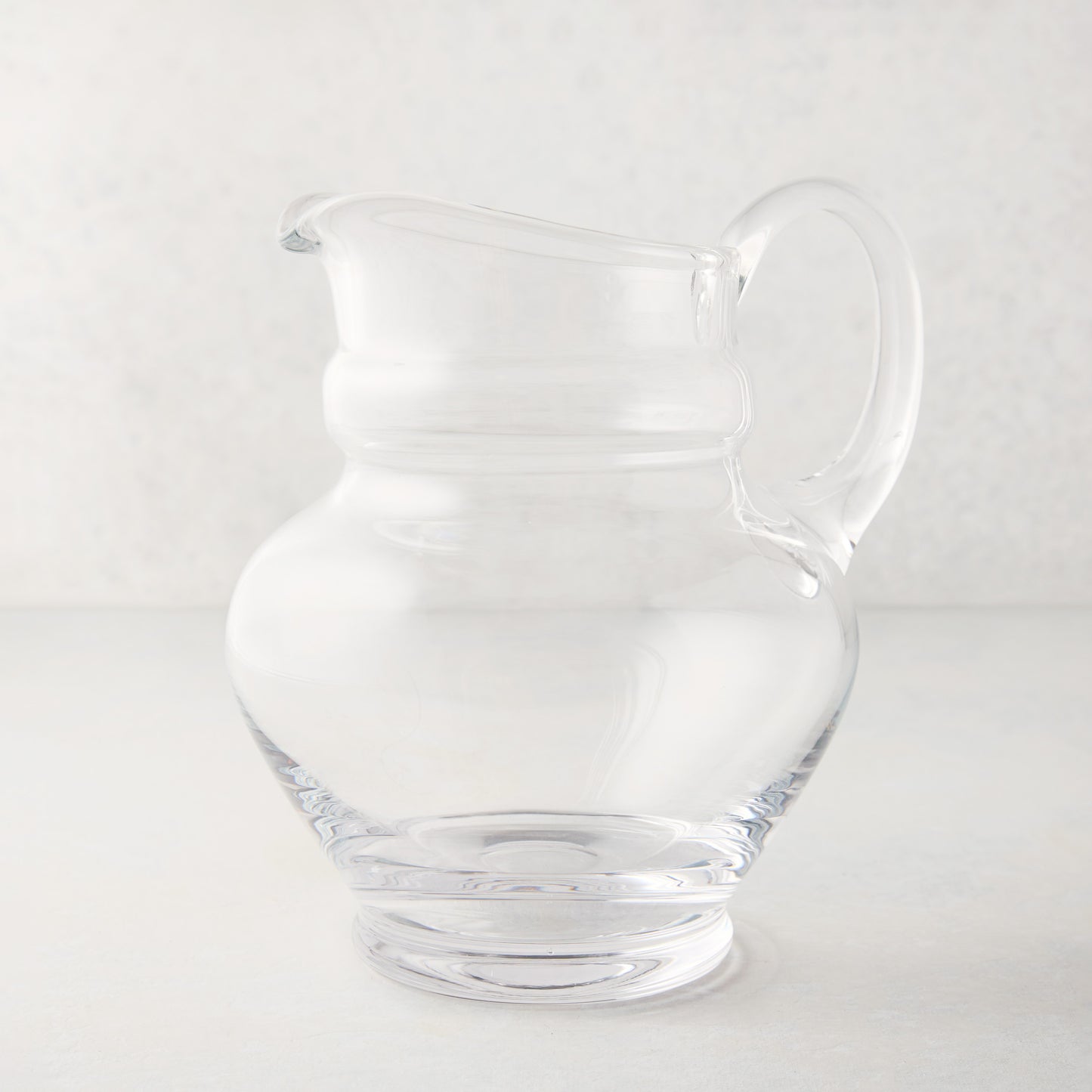Clear, hand-blown Sutton Glass Pitcher with unique shape and handle.