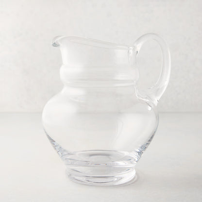 Clear, hand-blown Sutton Glass Pitcher with unique shape and handle.
