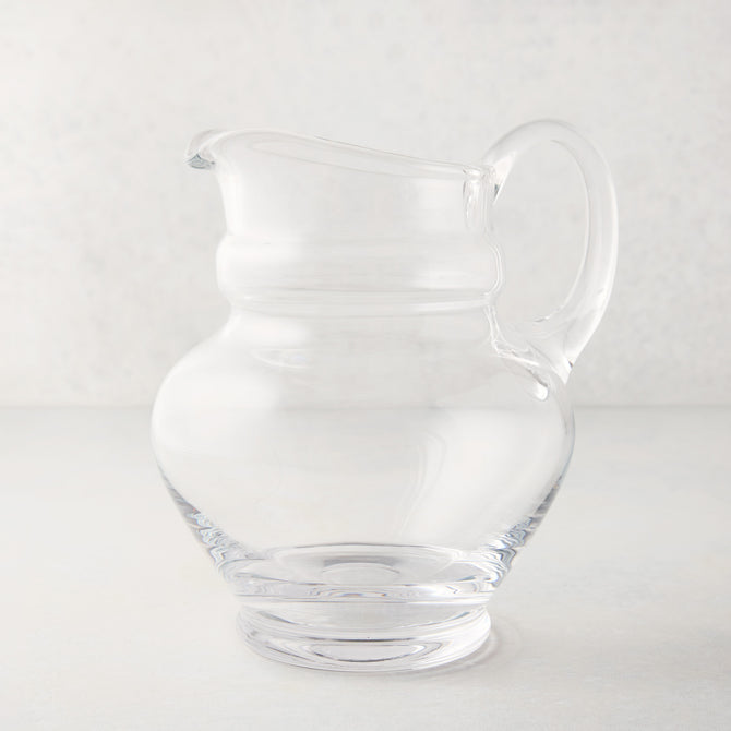Clear, hand-blown Sutton Glass Pitcher with unique shape and handle.