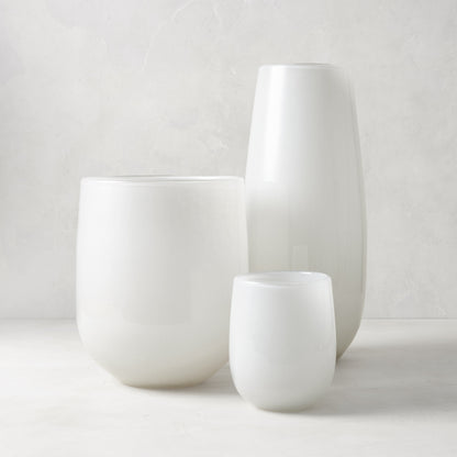 Three handblown opaque white glass barrel vases in varying sizes.
