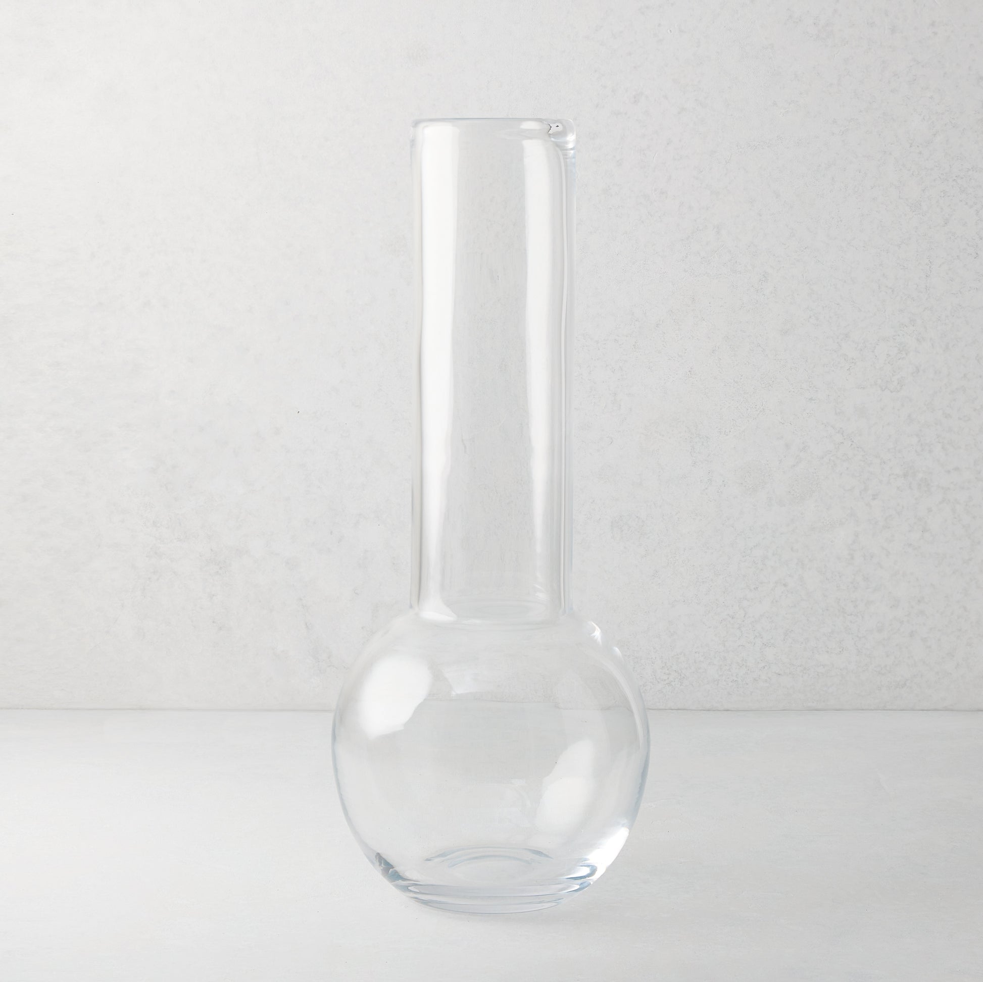 Sofia 17.5"H clear mouth-blown glass vase with a round base and tall, narrow neck.
