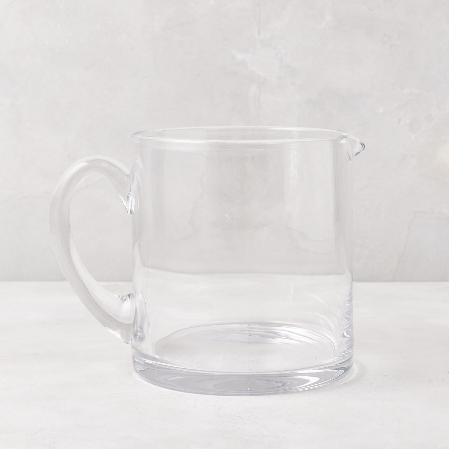 Soho Short Glass Pitcher, clear hand-blown glass, wide design, with handle and pour spout.