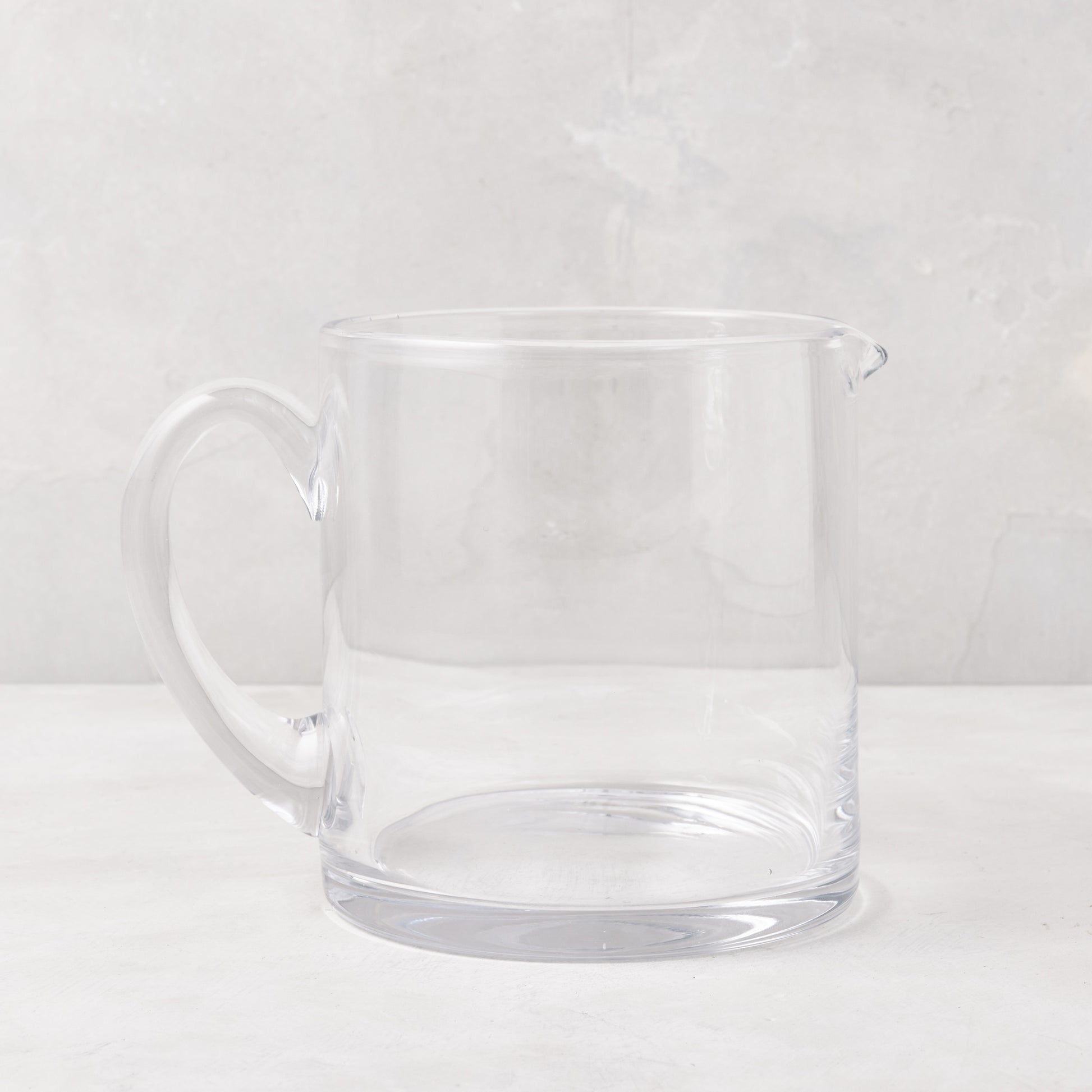 Soho Short Glass Pitcher, clear hand-blown glass, wide design, with handle and pour spout.