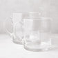 Two clear, hand-blown glass Soho Short Pitchers, one 40 oz and one 56 oz, with handles and spouts.