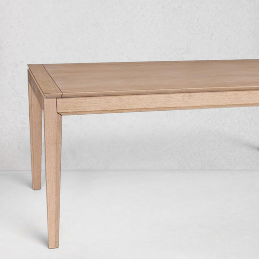 Solstice extendable oak dining table with a clear finish, showing its sleek, modern design.