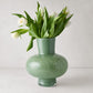 Sonia oversized opaque green handblown glass vase with white tulips.