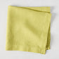 HG Sour Apple hand-dyed linen napkin, 22-inch square, folded on a light background.