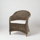 Southern French Arm Chair, natural rattan with woven texture and white cushion.