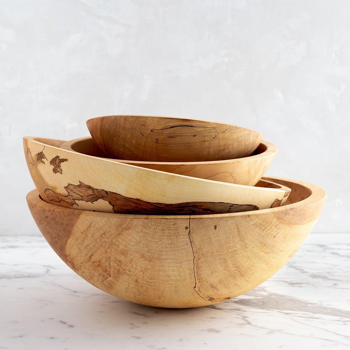 Stacked spalted maple wood bowls, natural light wood with unique dark grain patterns.