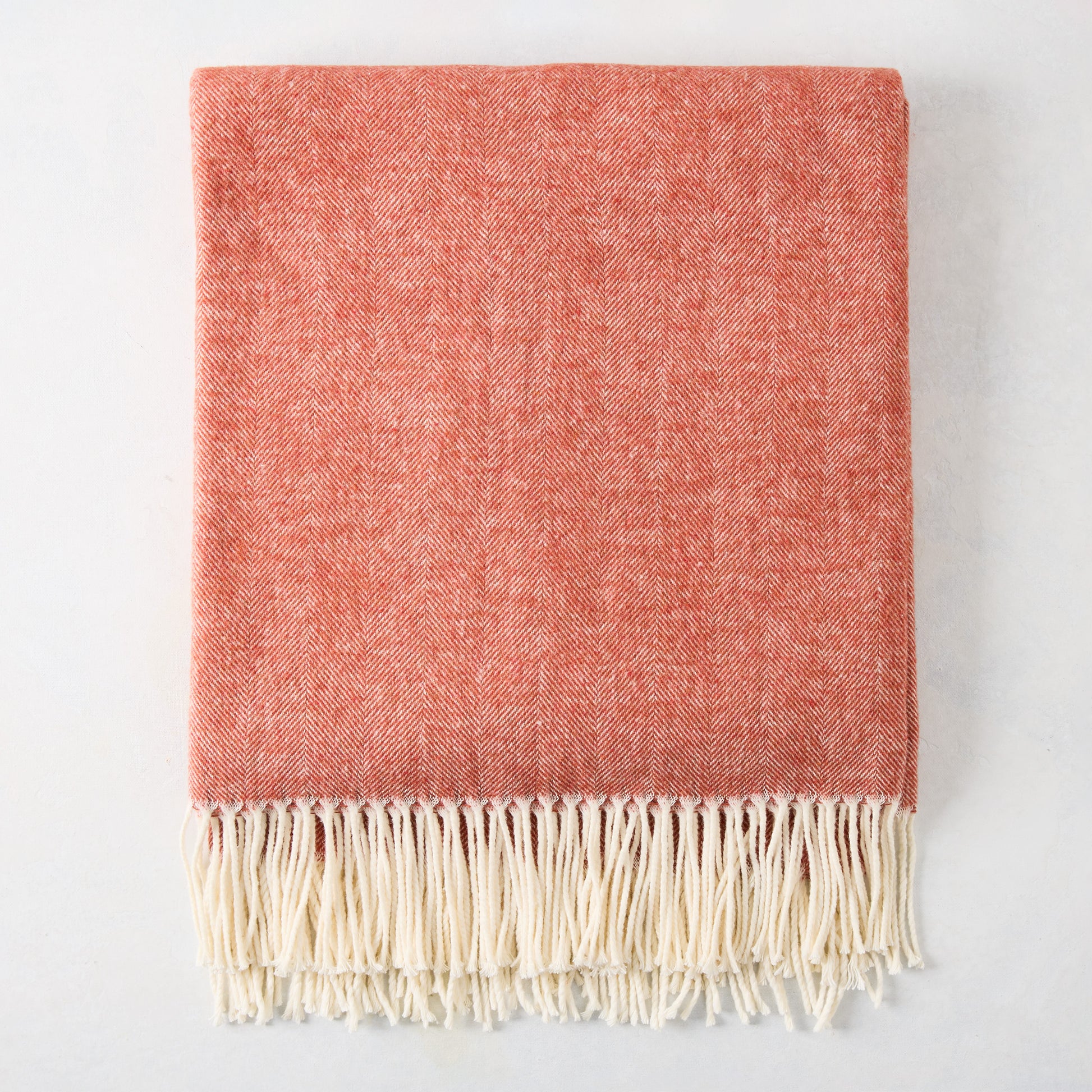 Spice Orange Italian Herringbone Throw Blanket, folded, with cream fringe.
