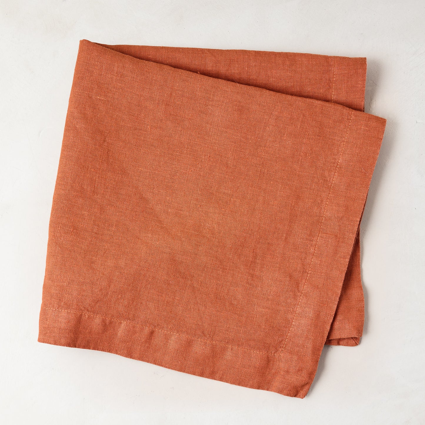 Spice HG Hand-Dyed Linen Napkin, 22" square, folded on a white surface.