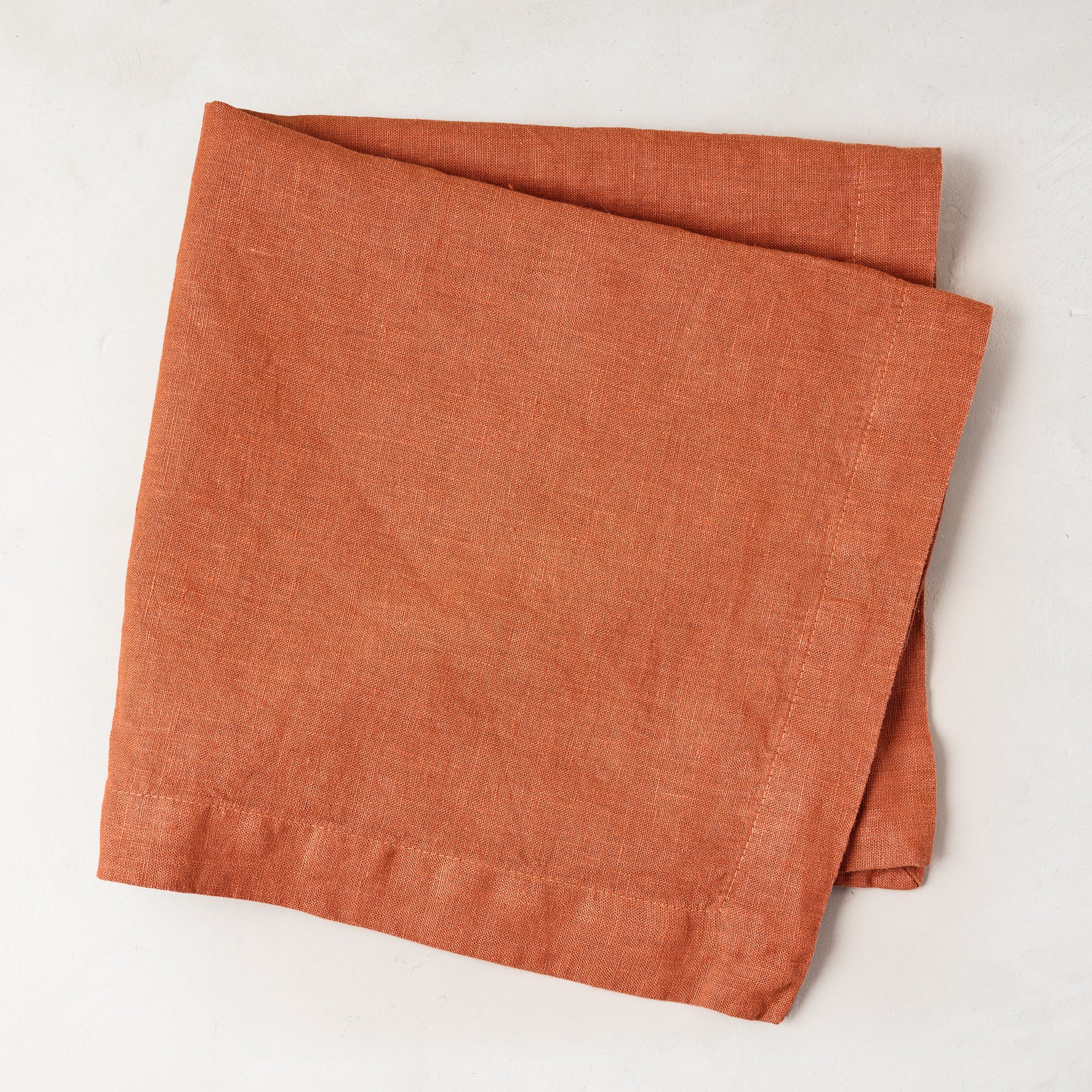 Spice HG Hand-Dyed Linen Napkin, 22" square, folded on a white surface.