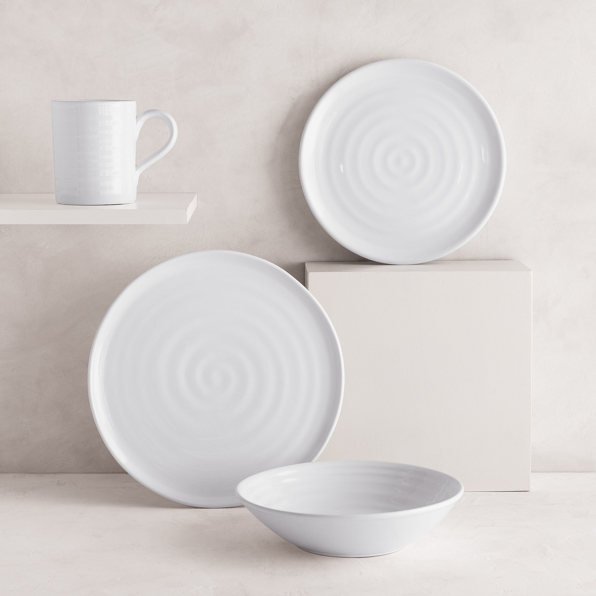 White ceramic Spiral Dinner Plate, mug, and bowl with subtle concentric ridges.