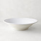 White ceramic flared serve bowl with subtle spiral texture, 15.5" diameter, handmade in Italy.