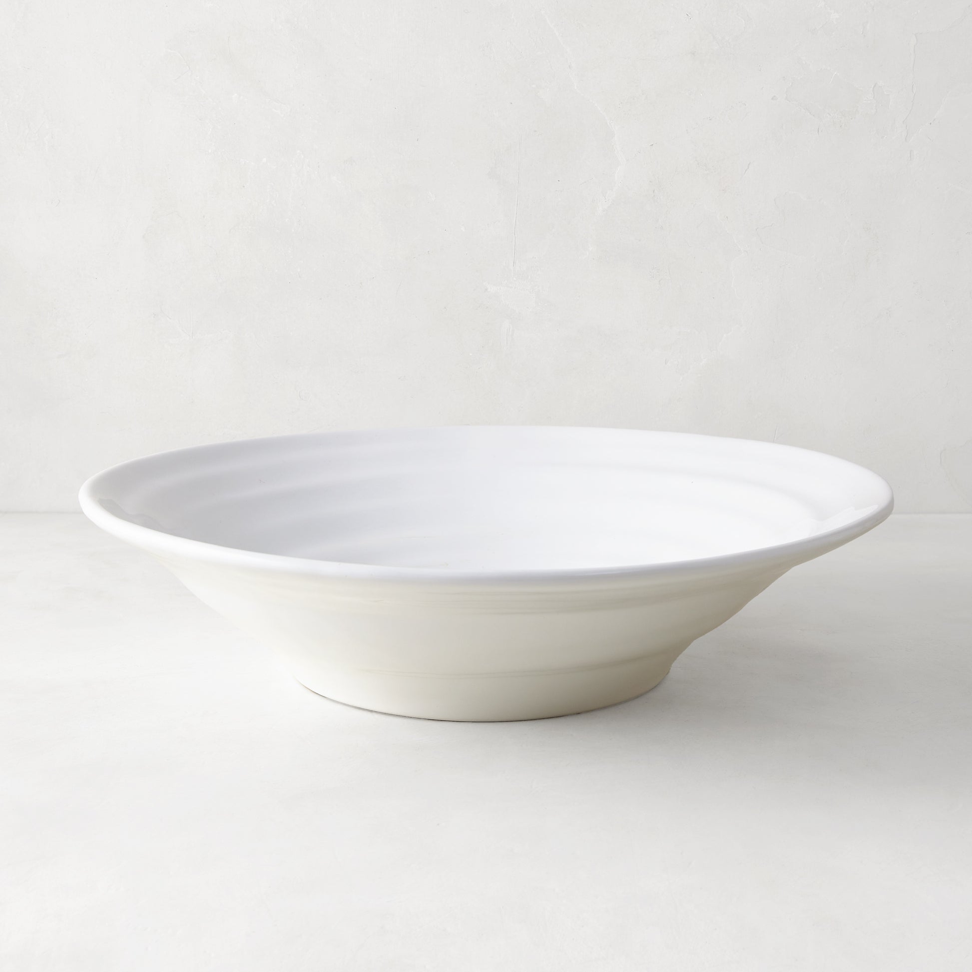 White ceramic flared serve bowl with subtle spiral texture, 15.5" diameter, handmade in Italy.