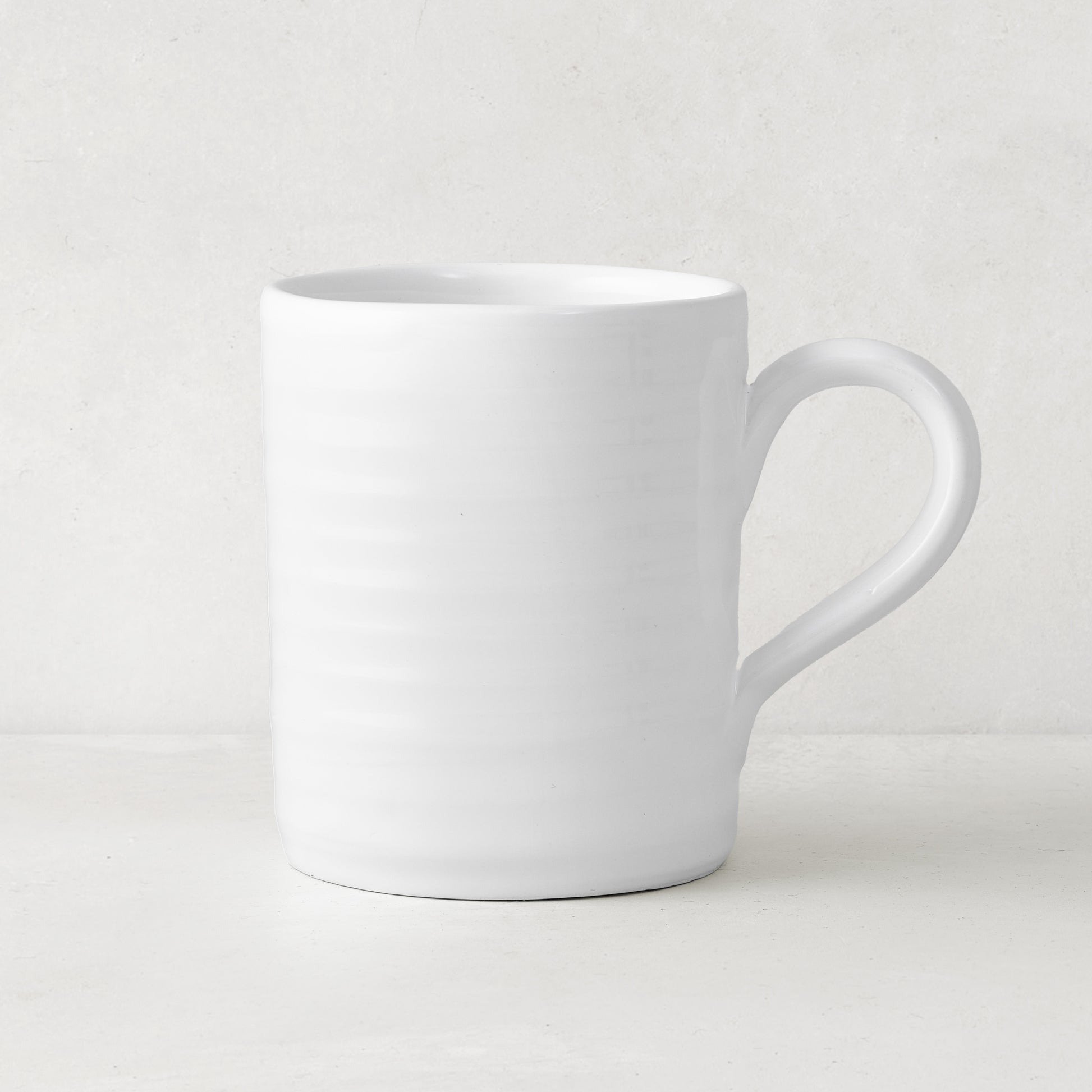 White ceramic Spiral Mug with subtle horizontal ridges and a curved handle.