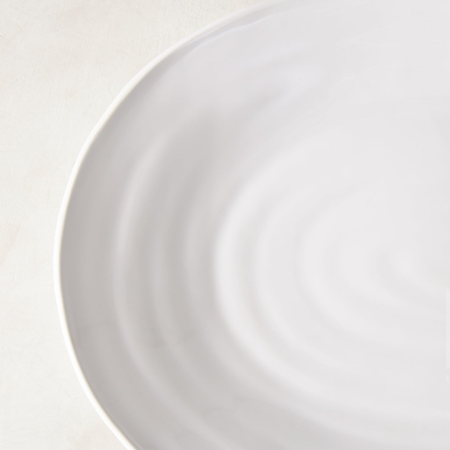 White spiral ceramic oval serving platter with a modern coupe edge.