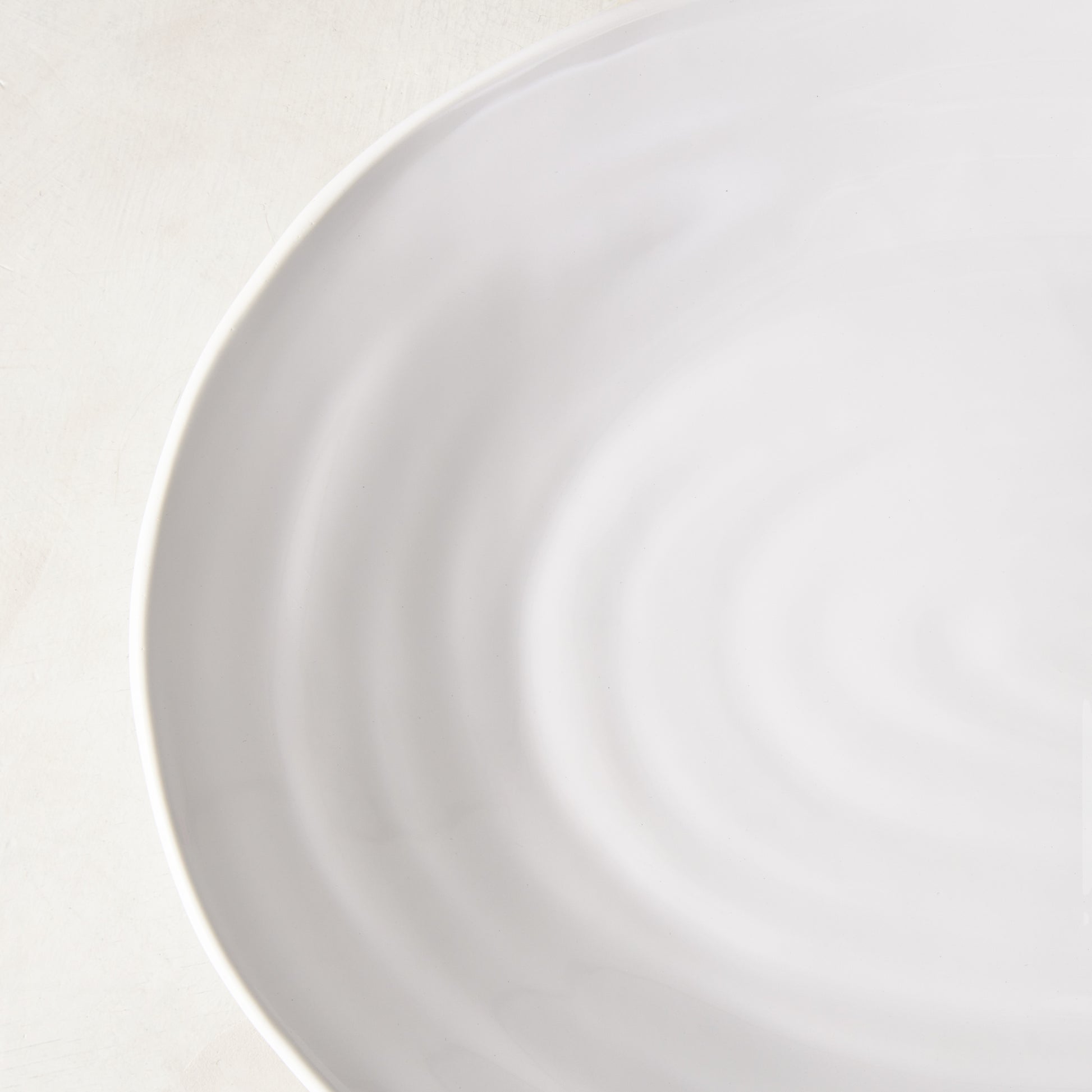 White spiral ceramic oval serving platter with a modern coupe edge.
