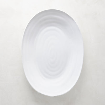 White ceramic oval serving platter with a subtle spiral design, 17"L x 12.5"W.