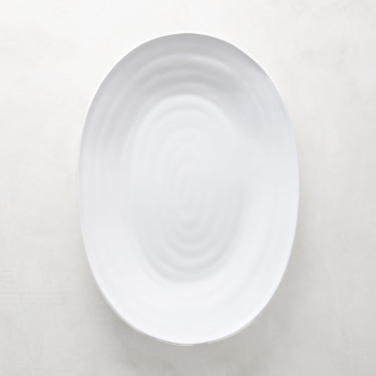 White ceramic oval serving platter with a subtle spiral design, 17"L x 12.5"W.