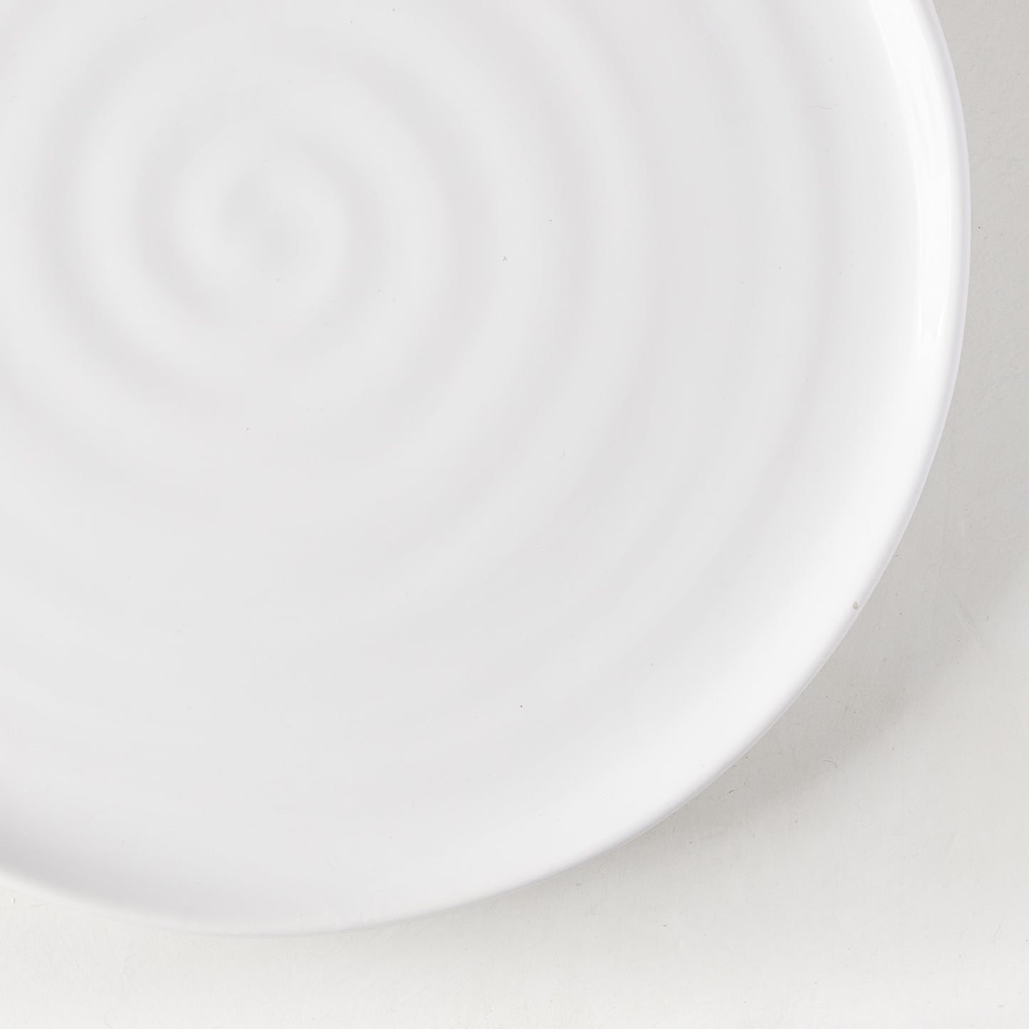 White ceramic salad plate with a subtle spiral design, 9" diameter.
