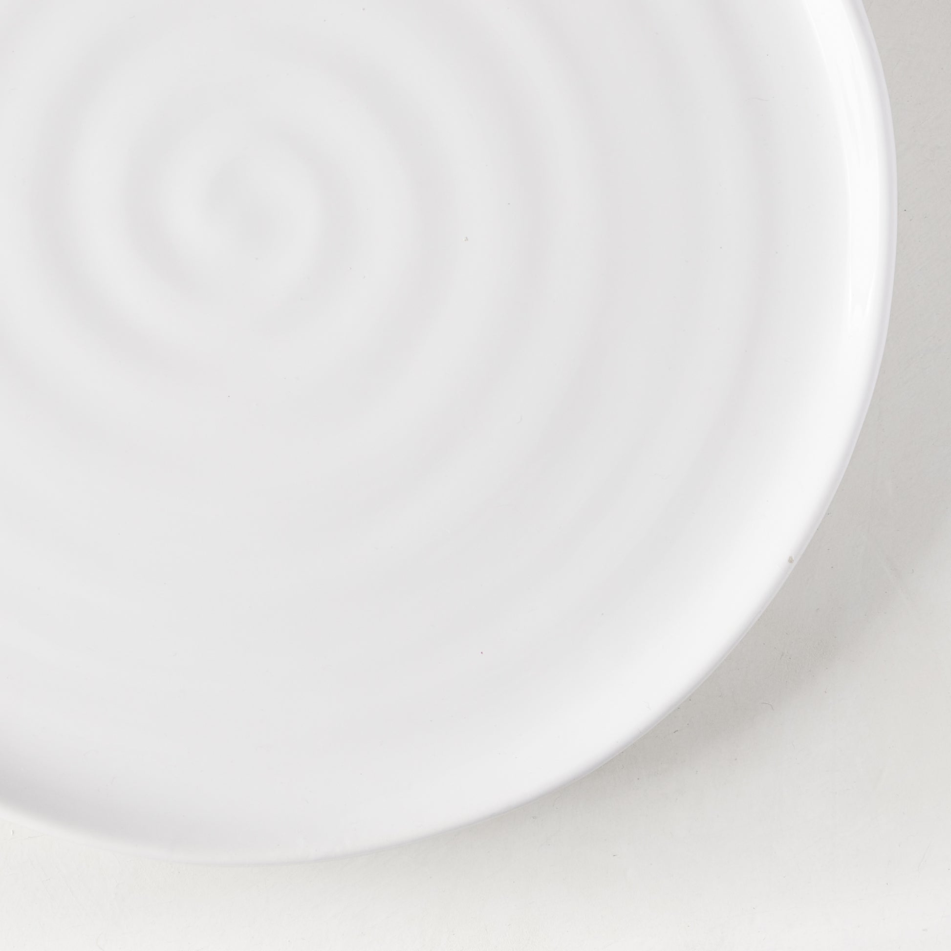 White ceramic salad plate with a subtle spiral design, 9" diameter.