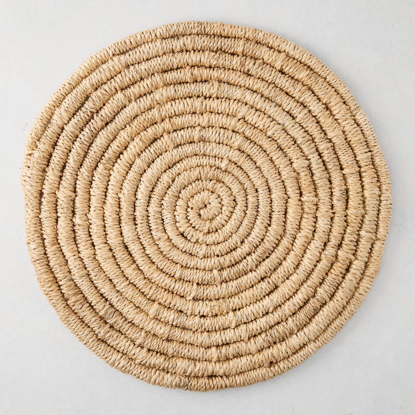 Round natural woven abaca placemat, 15" Dia, honey-brown hue, handcrafted, spiral design.
