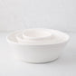 Set of 3 white ceramic spiral stacking serve bowls, small, medium, and large.