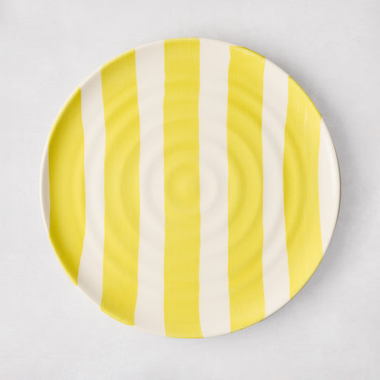 Handmade Italian ceramic salad plate with yellow vertical stripes and subtle spiral grooves.