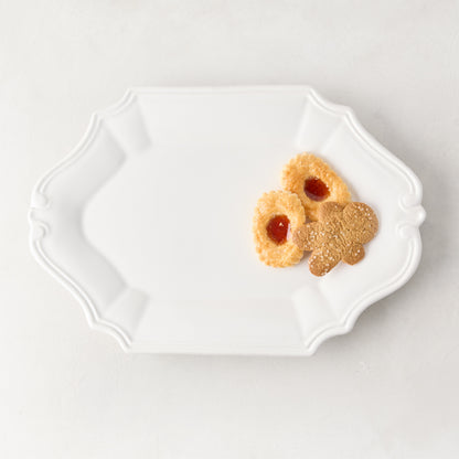 White Sprezzatura ceramic serving platter with detailed edges, holding three cookies.