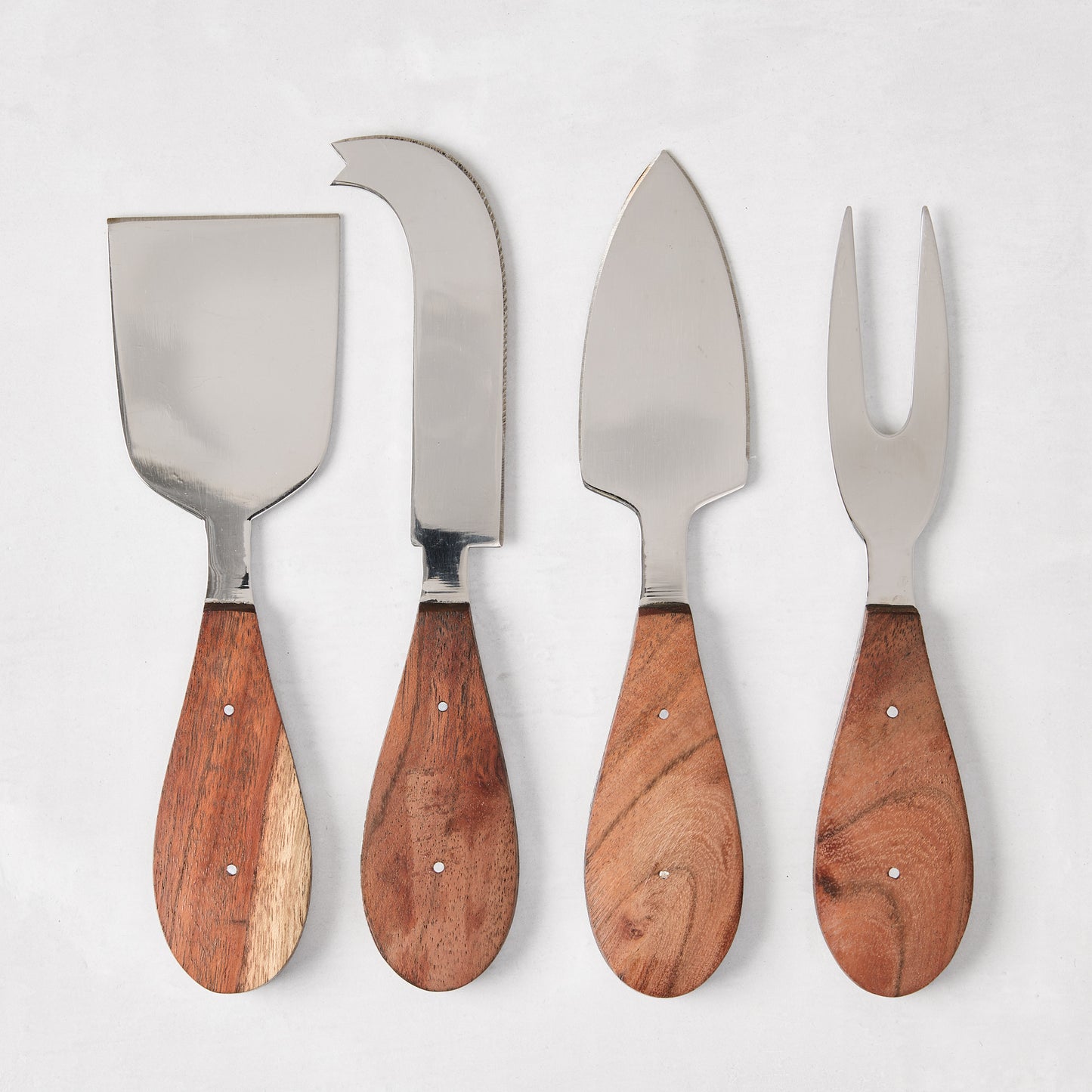 Four stainless steel cheese knives with warm brown wood handles, including a spreader, cleaver, spade, and fork.