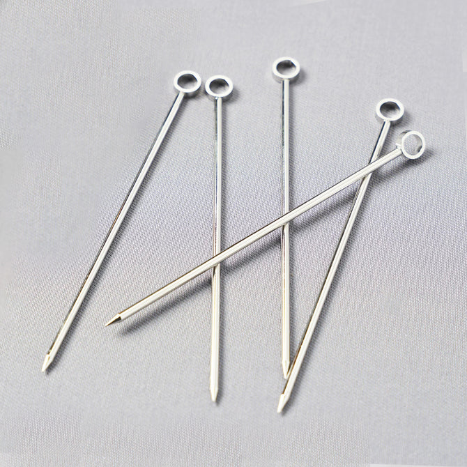 Set of six silver stainless steel cocktail picks, 3.75"L, with a ring top design.
