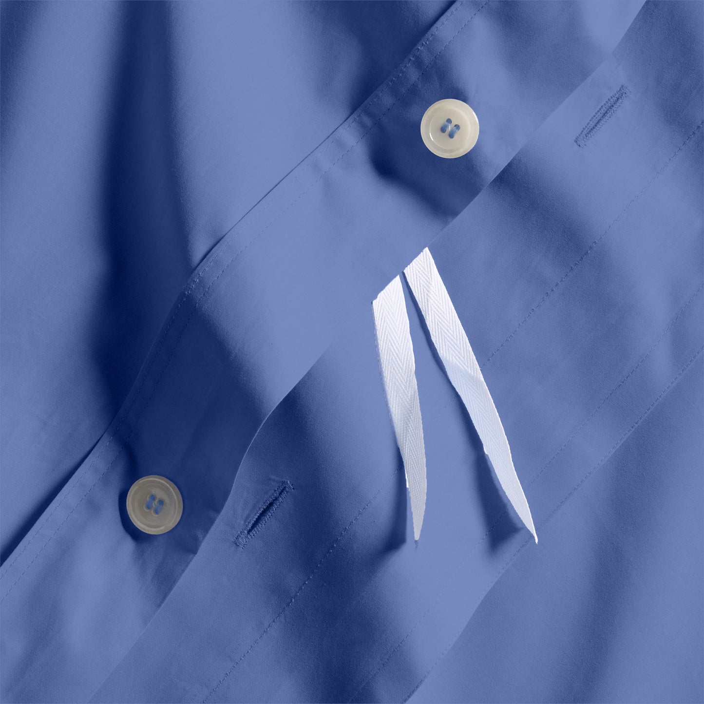 Close-up of Steele Blue Italian Percale Duvet Set with button closures and white fabric ties.