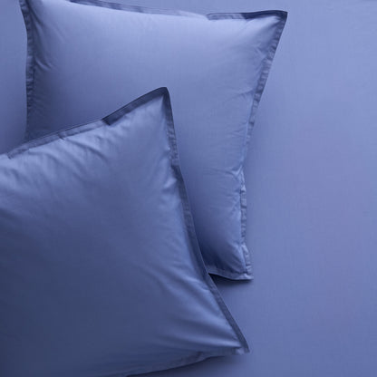 Set of 2 Steele Blue Italian Percale Euro Shams with envelope closures, shown on matching bedding.