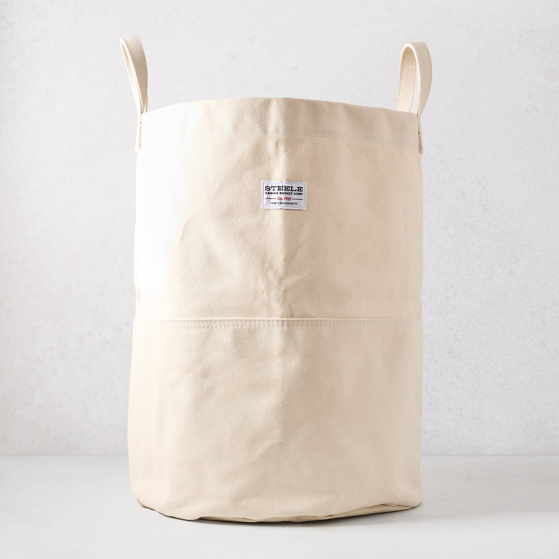 Steele natural-toned canvas storage bin with two handles and a brand label.