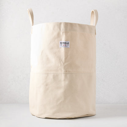 Steele natural-toned canvas storage bin with two handles and a brand label.